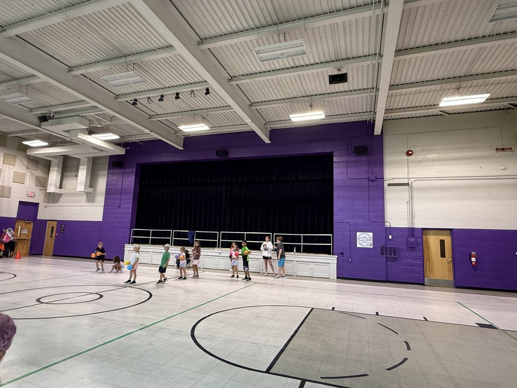 A group of students playing inside a school gym.