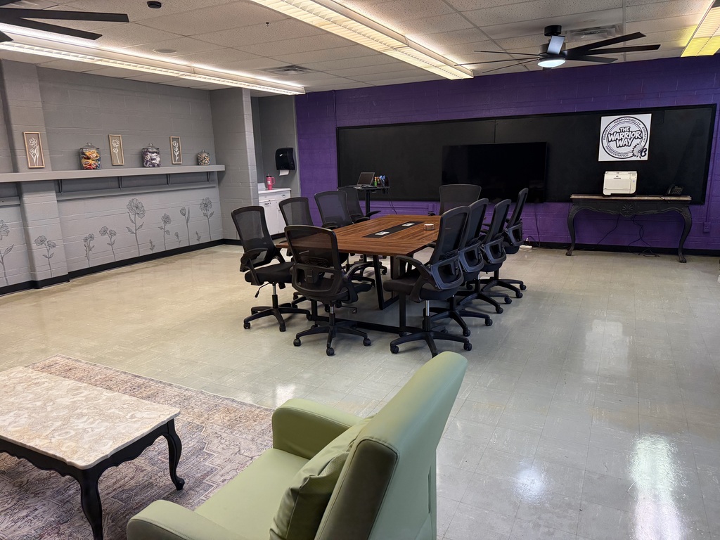 A school classroom with a purple wall and new desk.