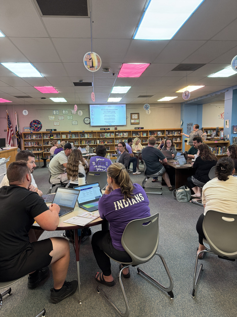 A room full of staff collaborating in a school library.