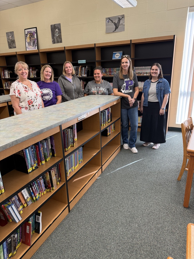 Six staff members posing in a school library.