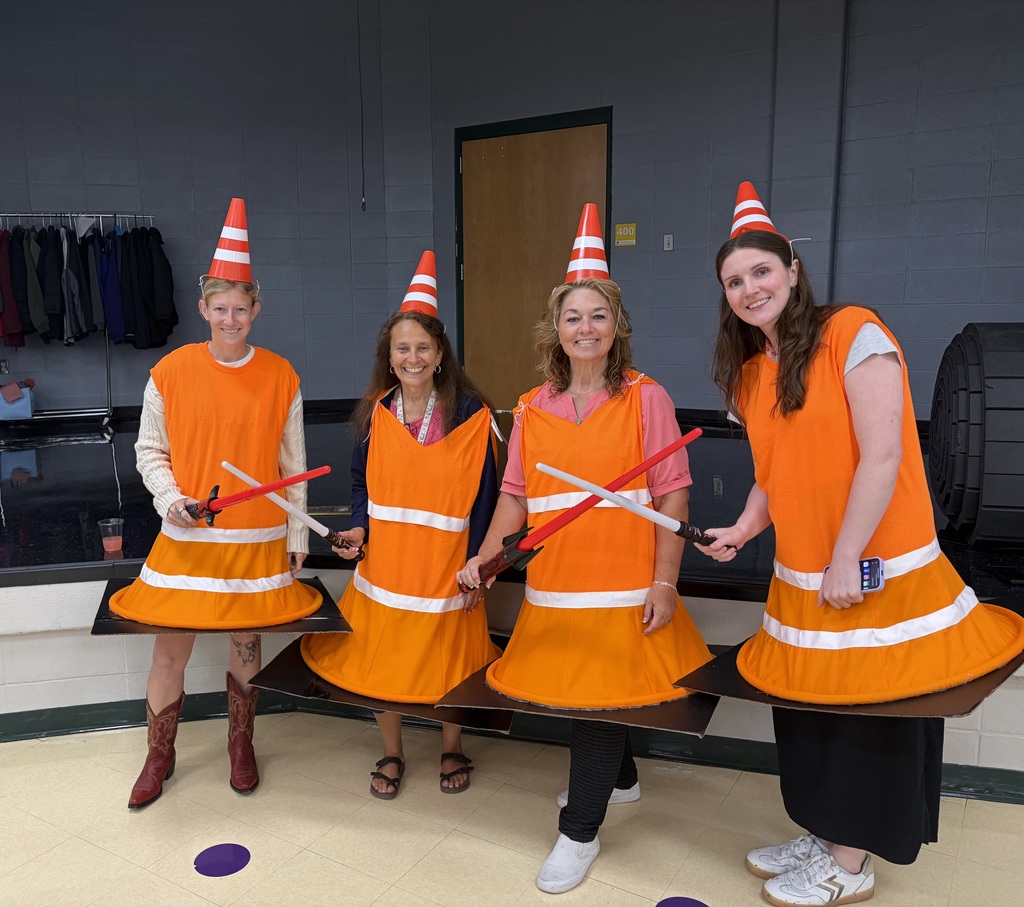 Four staff members wearing traffic cone costumes.