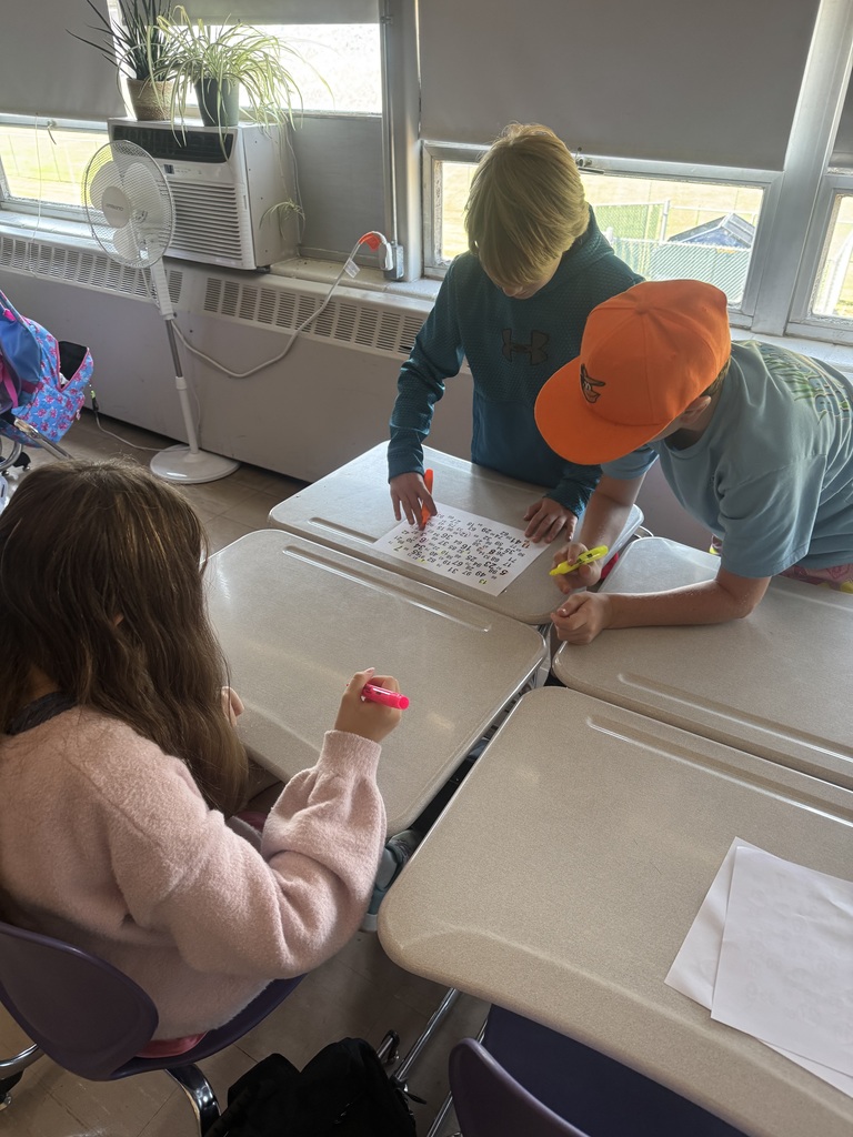 Three students working on a puzzle in a school classroom.
