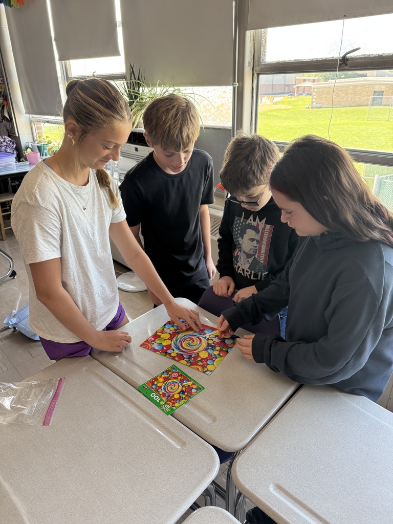 Four students working on a puzzle in a school classroom.