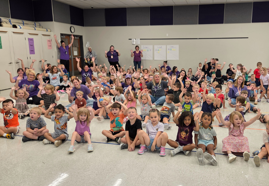 A school gym full of young students celebrating.