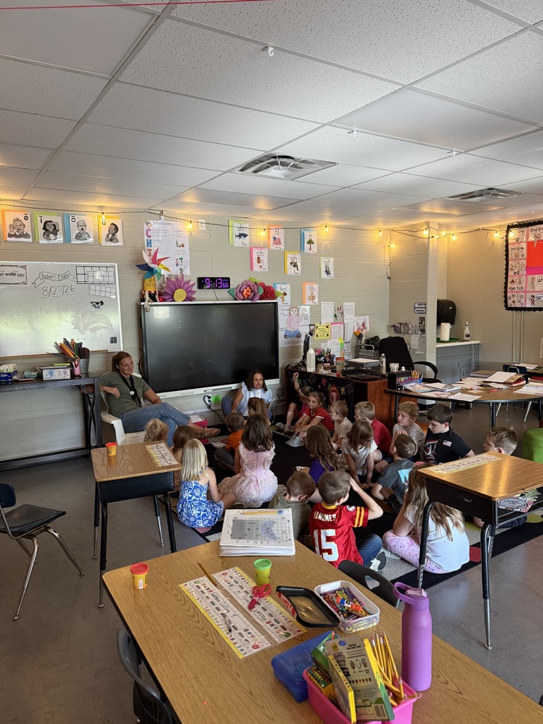 Two elementary classrooms show teachers leading groups of young students seated together on classroom rugs.