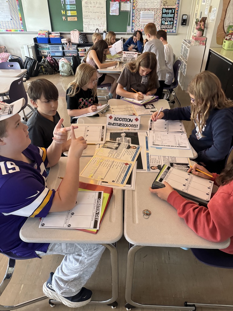 Students work in small groups on an “Order of Operations Hospital” math activity using patient charts and worksheets.