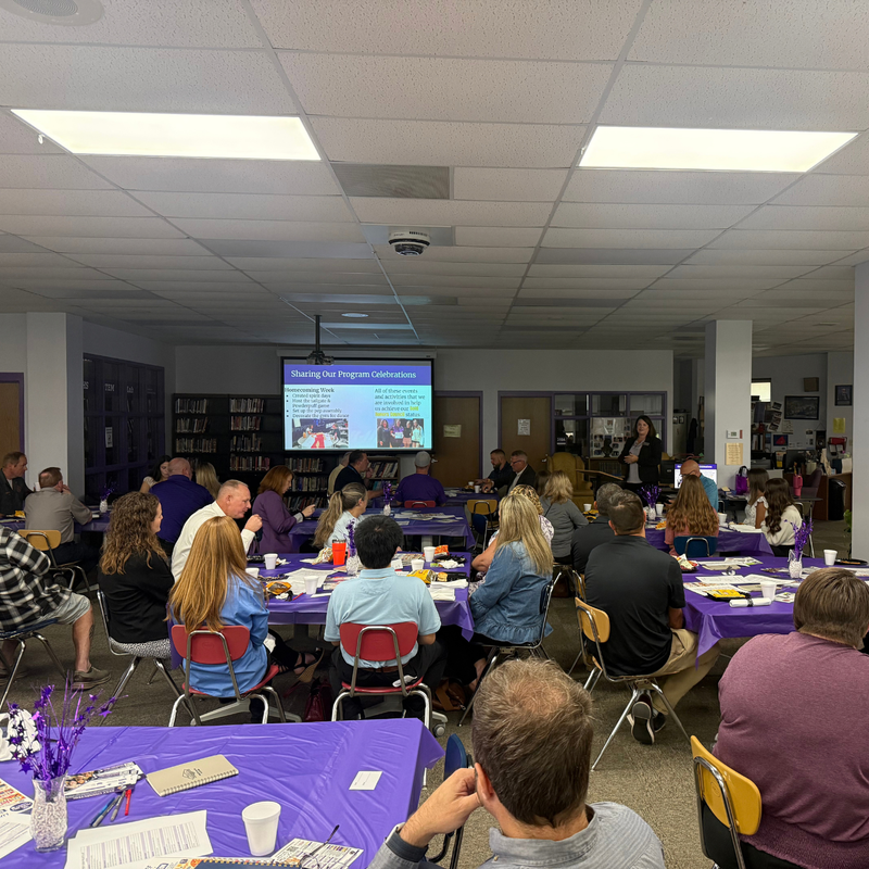 A group of adults gathered in a room for a presentation.