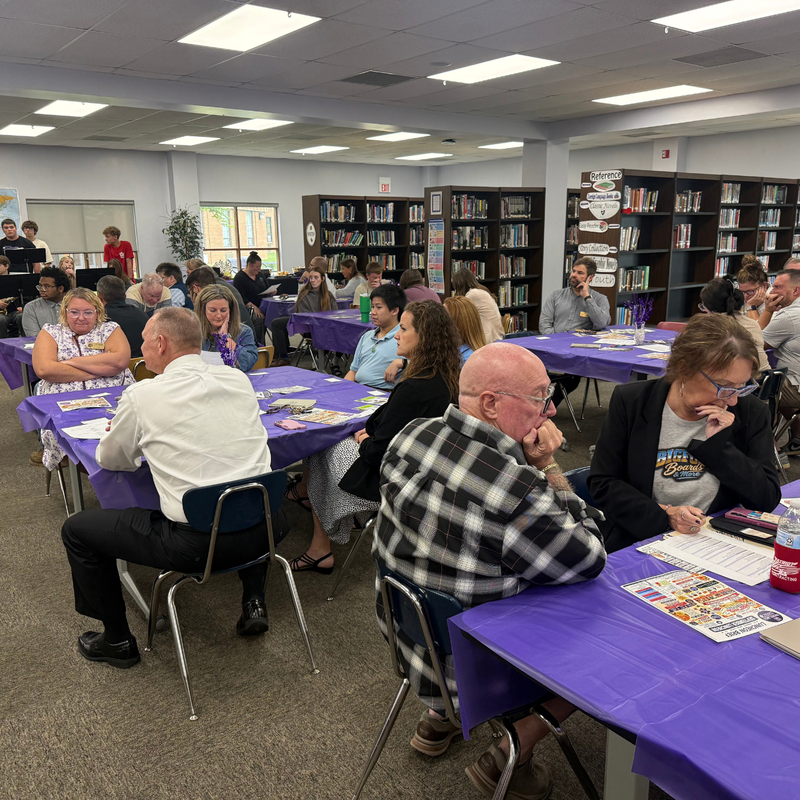 A group of adults gathered in a room for a presentation.