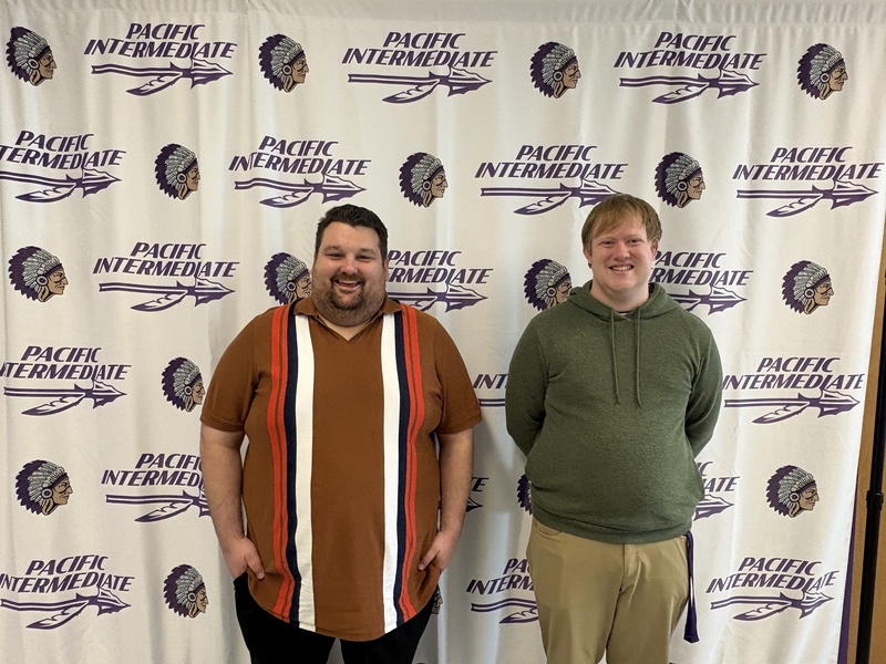 Joe Elbert, Special Education Teacher and Travis Stahlman, Paraprofessional posing in front of a Pacific Intermediate background.