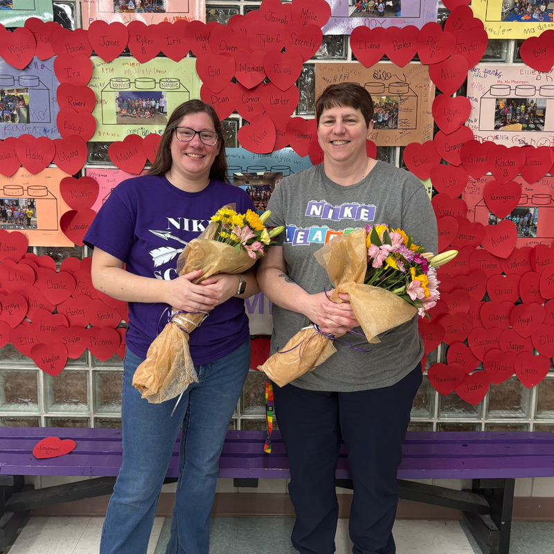 Amber Gann, Second Grade Teacher and Shanna Raeker, School Counselor posing with flower bouquets. 