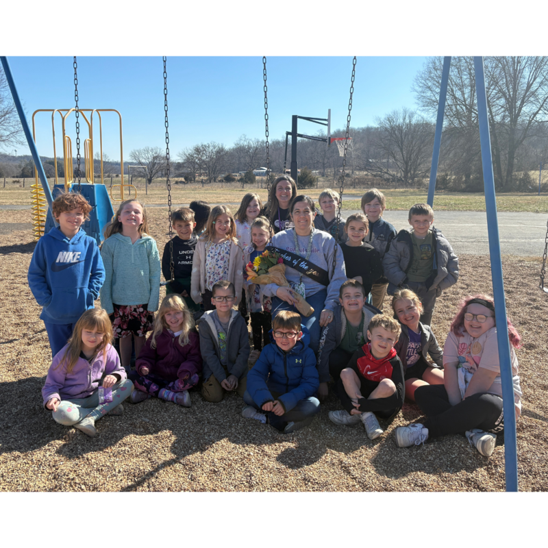 Amber Bartel, First Grade Teacher posing with students outside.