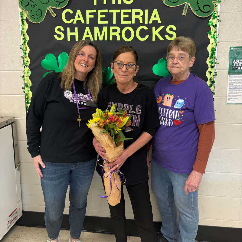 Michelle Miller, Kitchen Lead posting with flowers in a group photo.