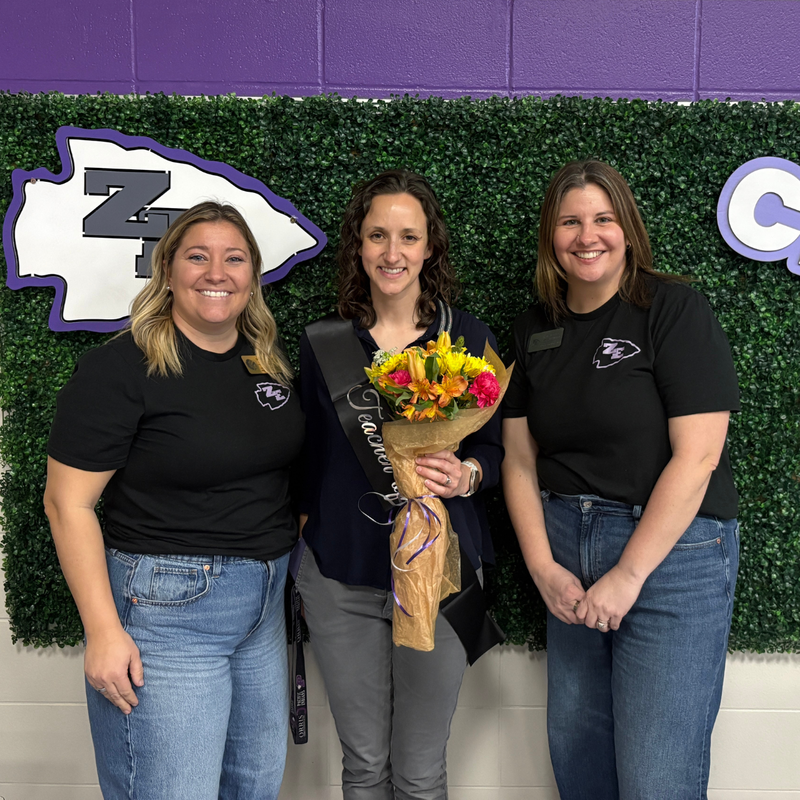 Allison Franzen, Music Teacher posing with flowers in a group photo.