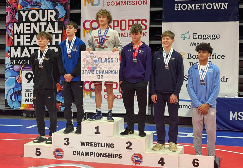 Boys wrestling champs on podium.