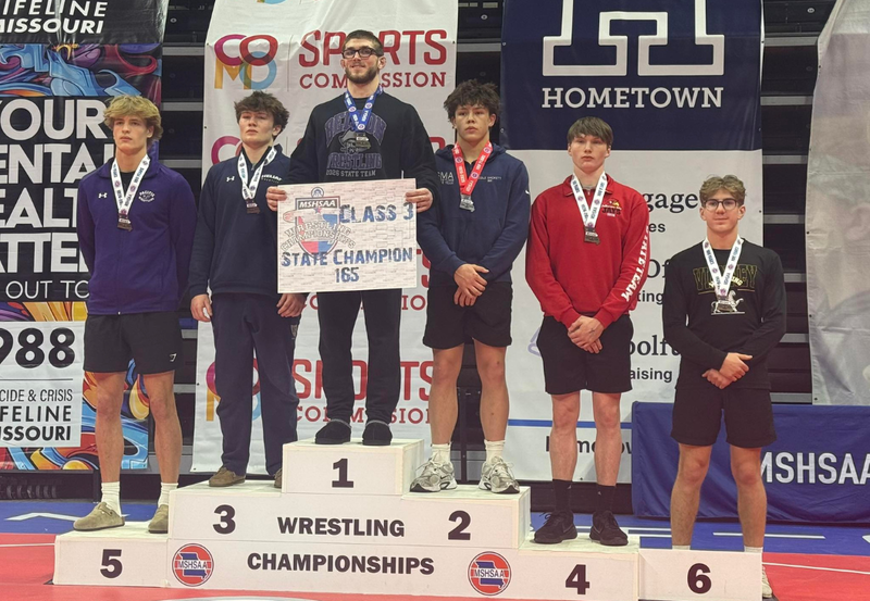 Boys wrestling champs on podium.