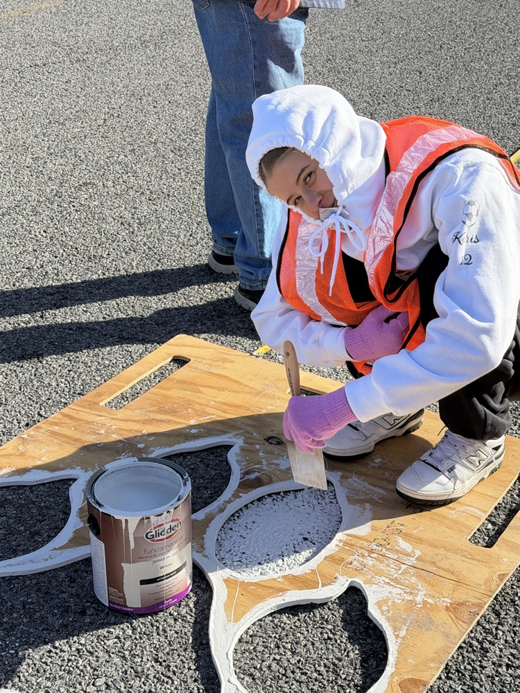 CU Bonner Scholar painting a paw print