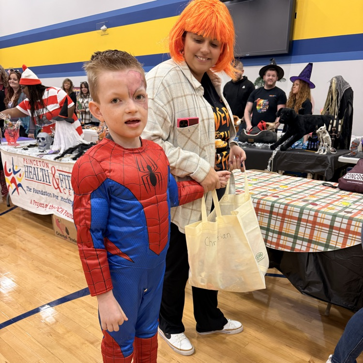 young blonde boy in a spider man costume trick or treating in the gym  