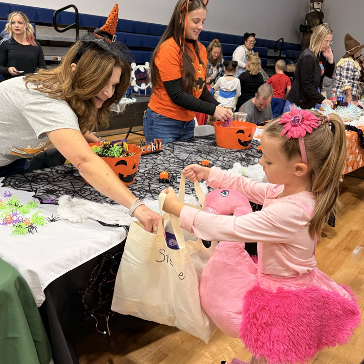 Little blonde hair girl dressed as a flamingo trick or treating in gym  