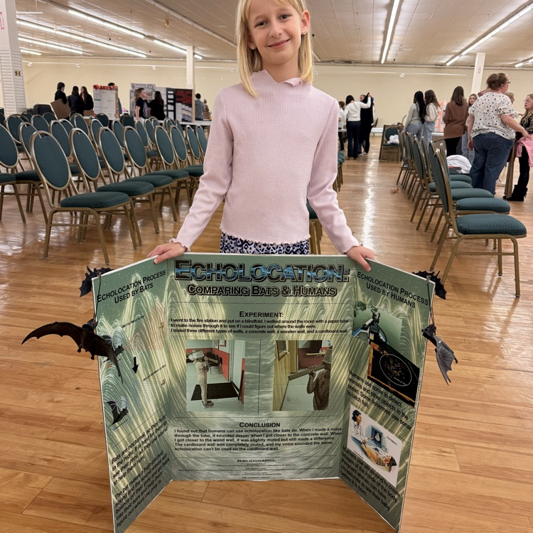 Blonde hair girl standing behind her bat- echolocation science fair project   