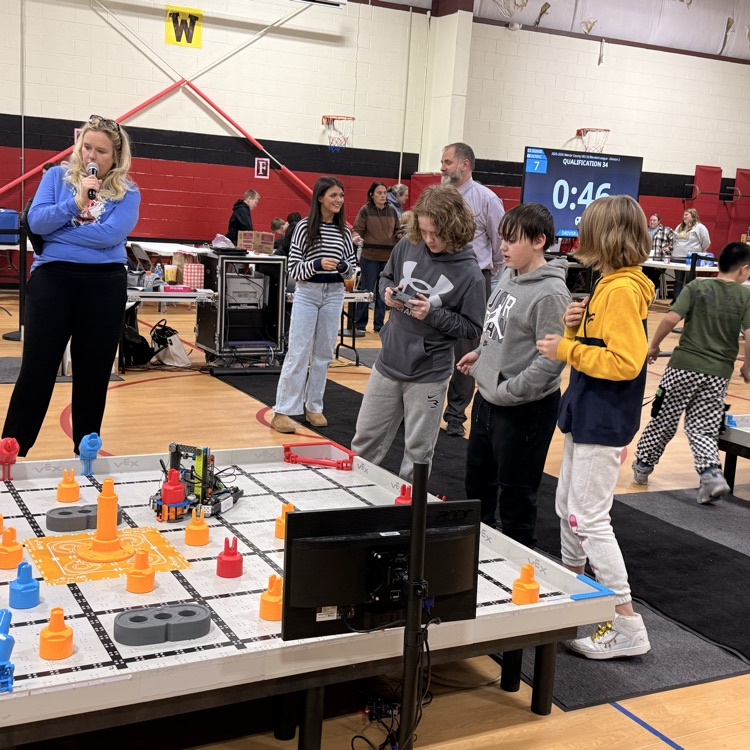 2 students competing at their robotics table in a competition  