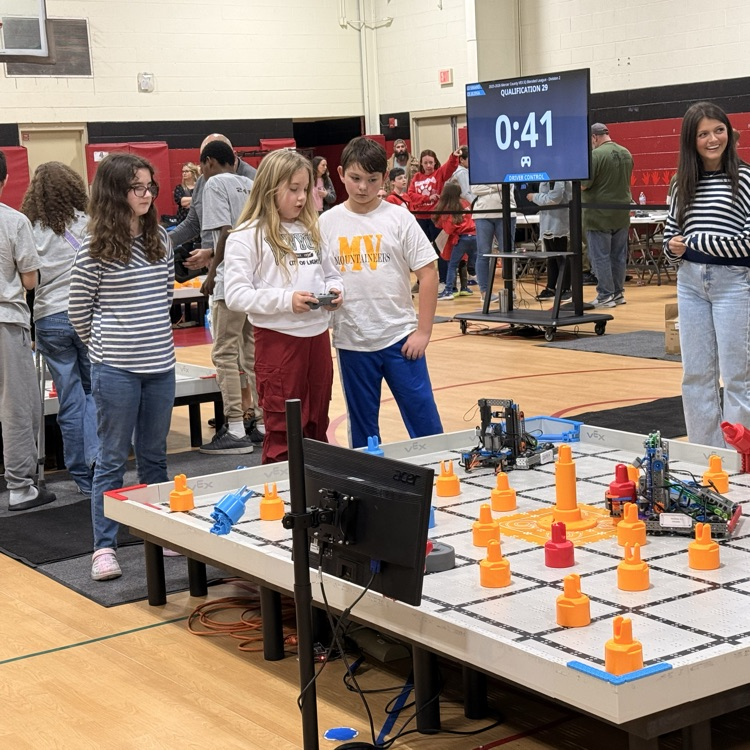 2 girls and a boy competing in the robotics competition  