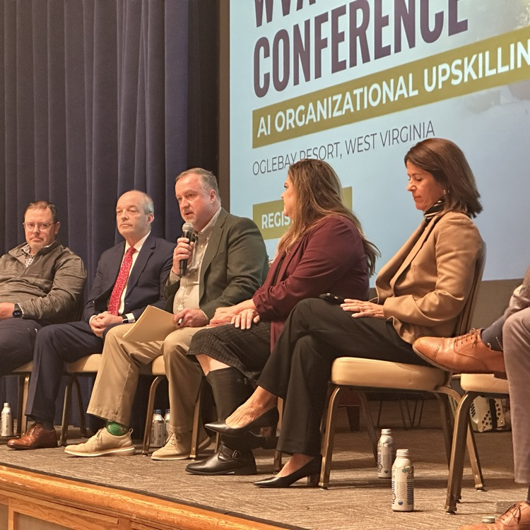 Dr. Adkins on a stage at the WVASA Conference participating in a town hall style discussion on the use of AI in our districts  AI in 