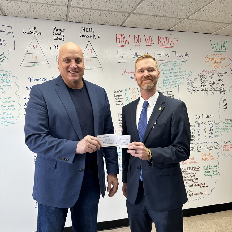 Judge Adam Wolfe and Superintendent Ed Toman showing donation check from Princeton Rotary for employee recognition banquets  