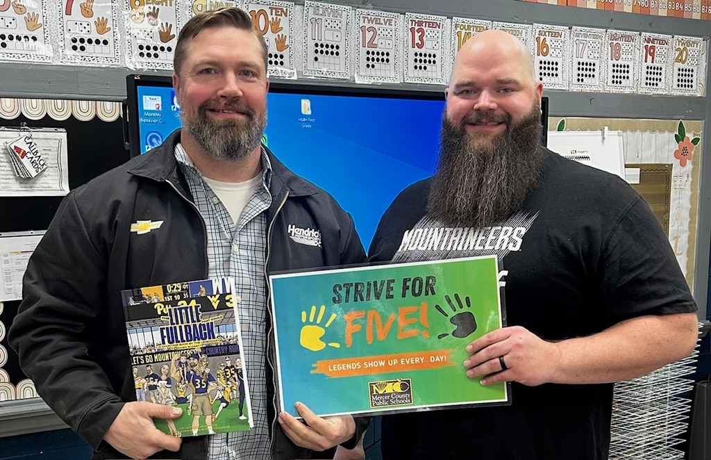 Mercer County Schools Attendance Director Russell Lippencott with former WVU football player, Owen Schmitt at Melrose School. Mr. Lippencott is holding a Strive for Five sign encouraging regular school attendance.
