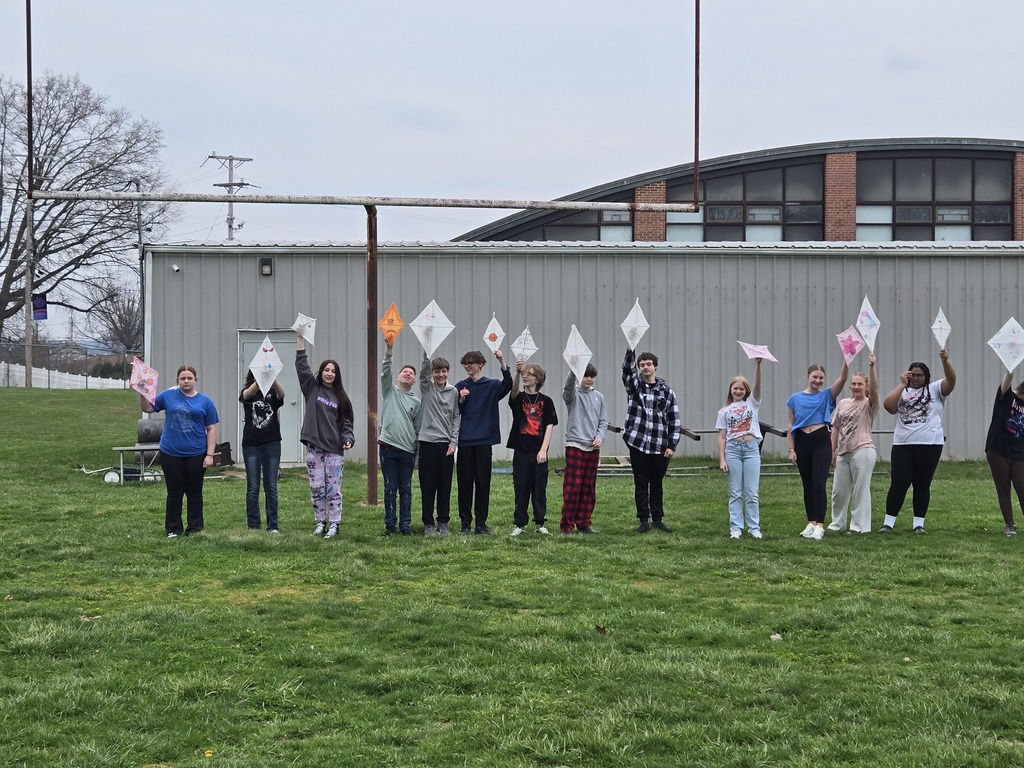students holding up kites