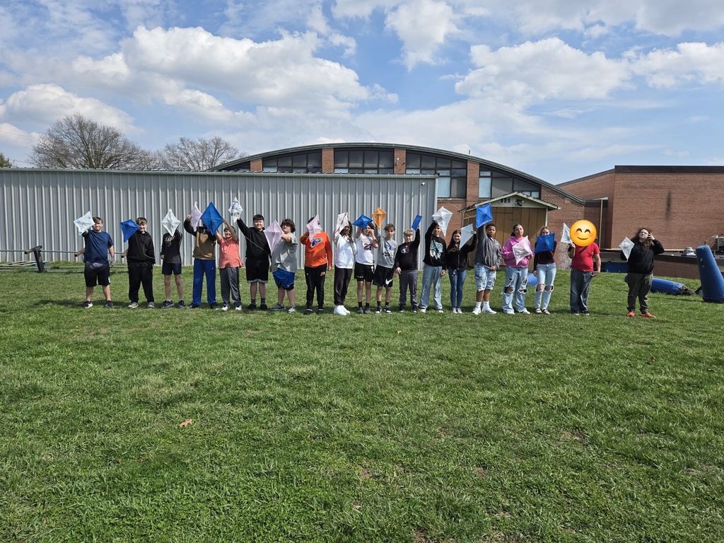 students holding up kites 