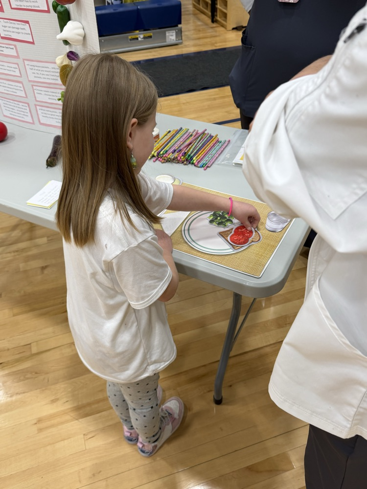 Girl placing fake fruit on plate 
