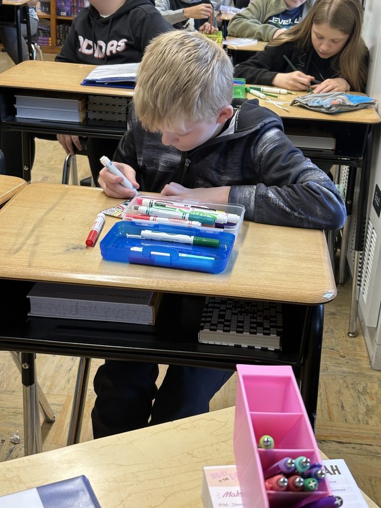 a student designing with markers at his desk