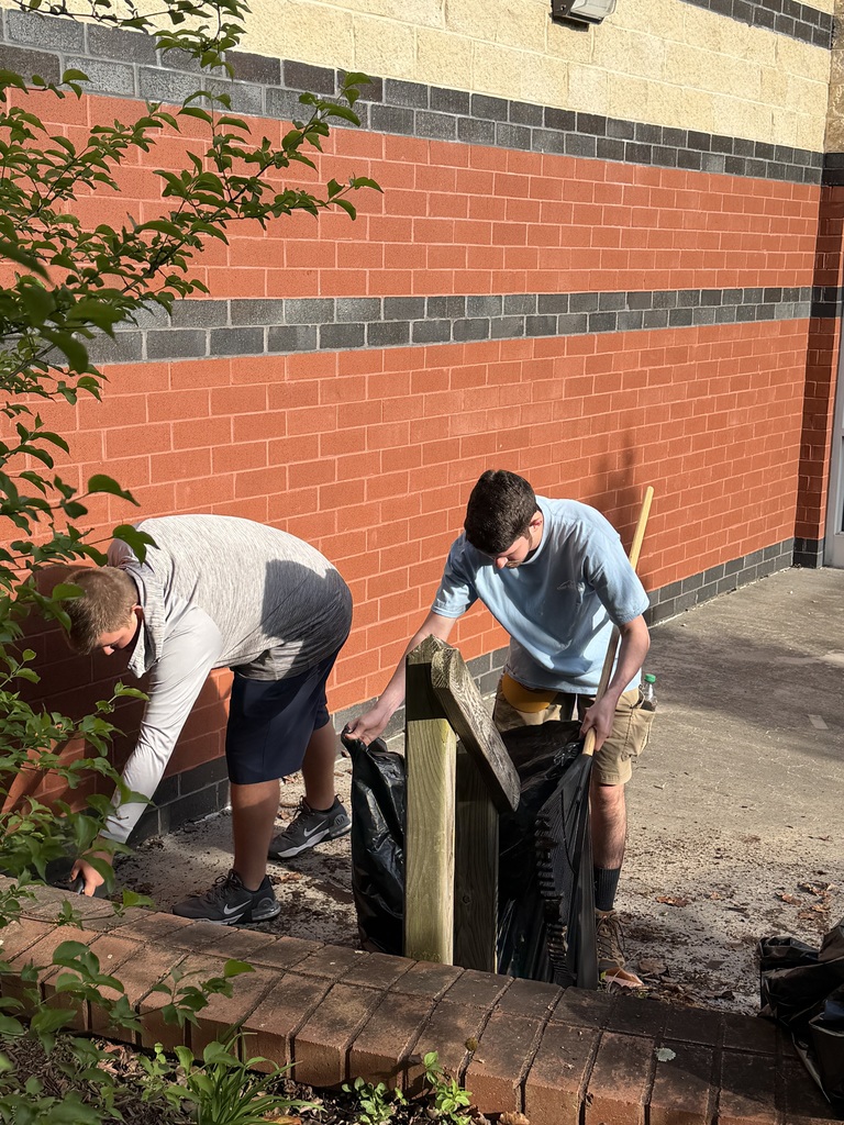 Students cleaning up a patio in the atrium