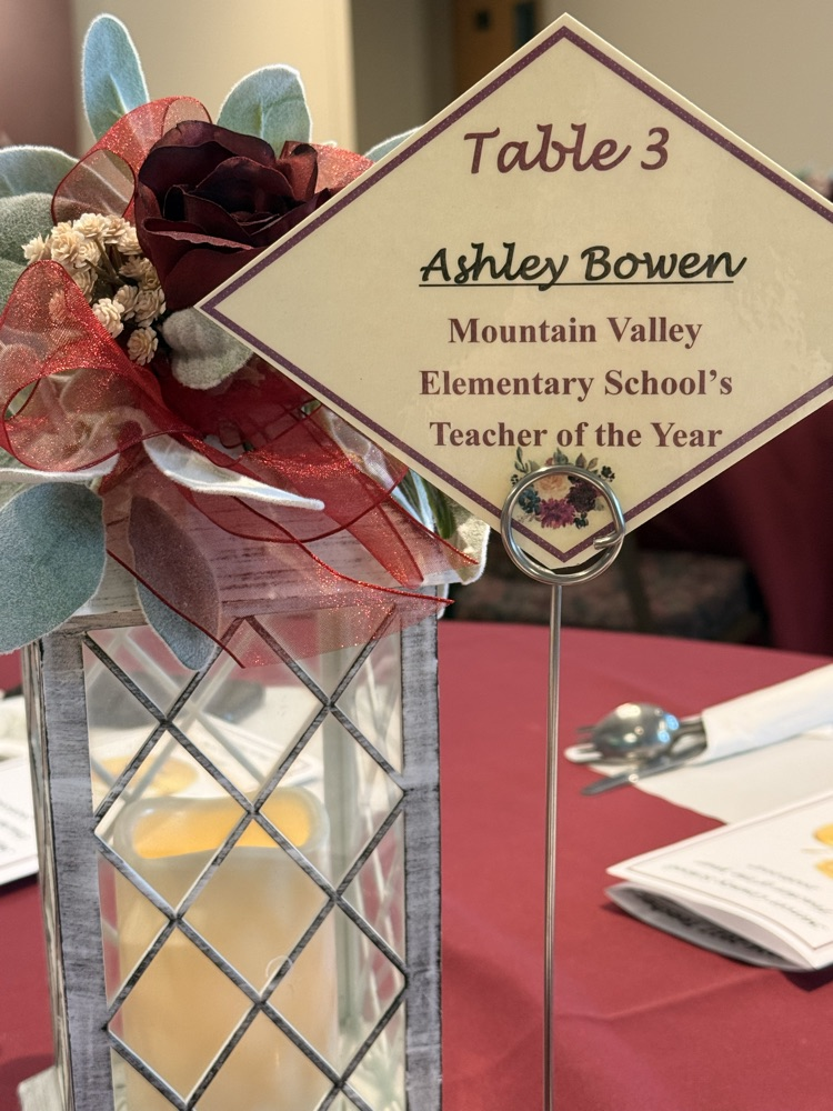 the table setting with a card that says “Ashley Bowen” Teacher of the Year  