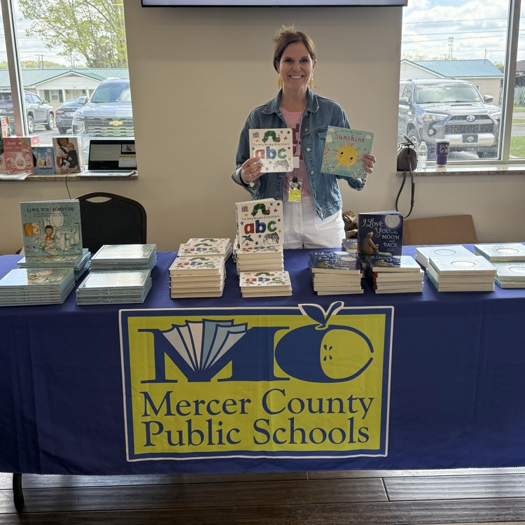 principal Emily Smith at the community baby shower handing out children’s books 