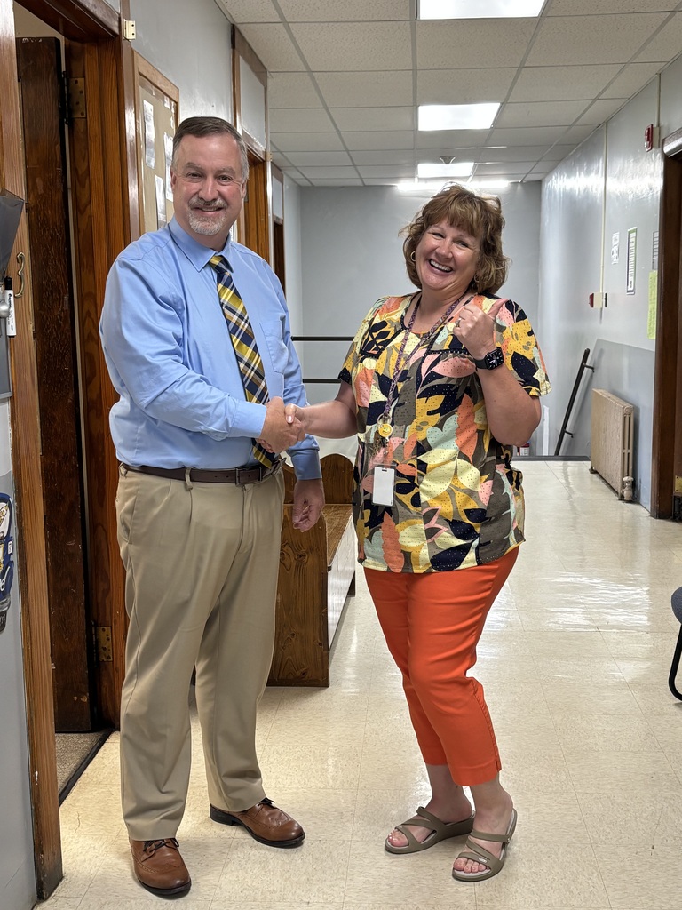 Dr. Adkins shaking Mrs. Booth's hand. She is showing a "thumbs up" sign.
