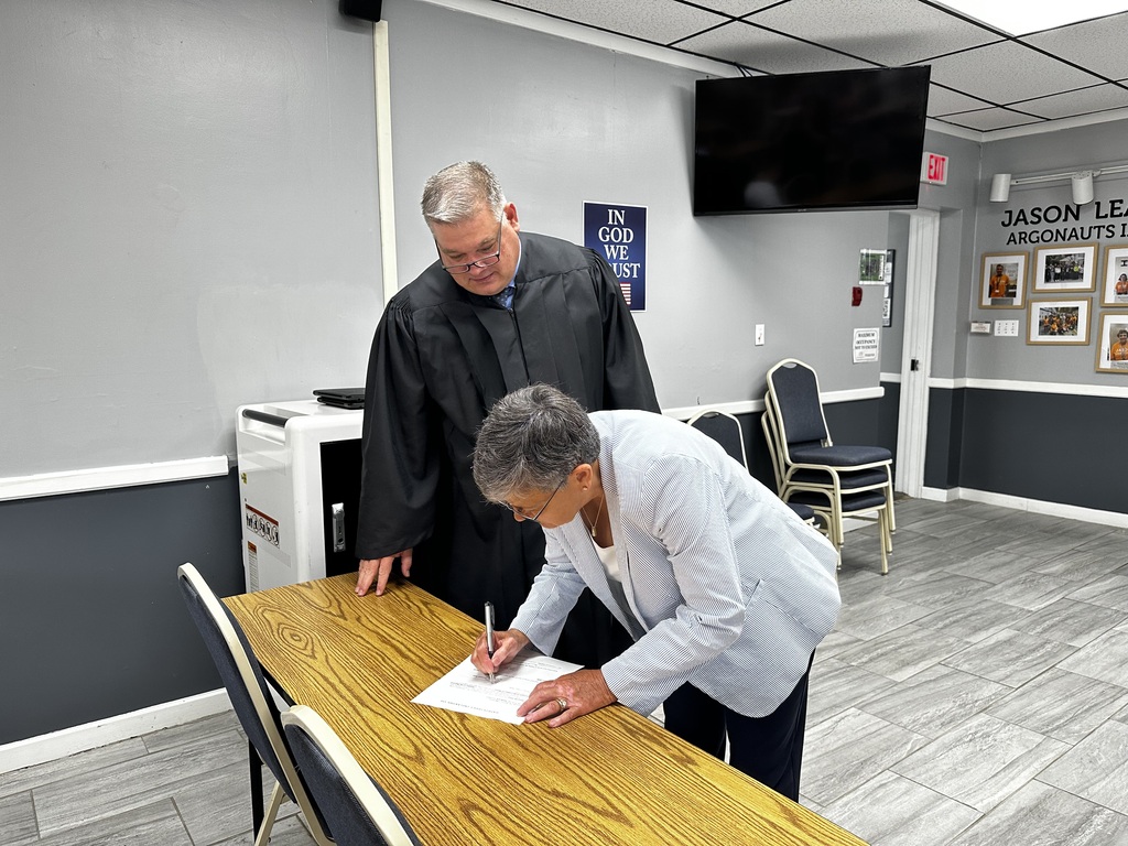 Dr. Akers signing the swearing in form.