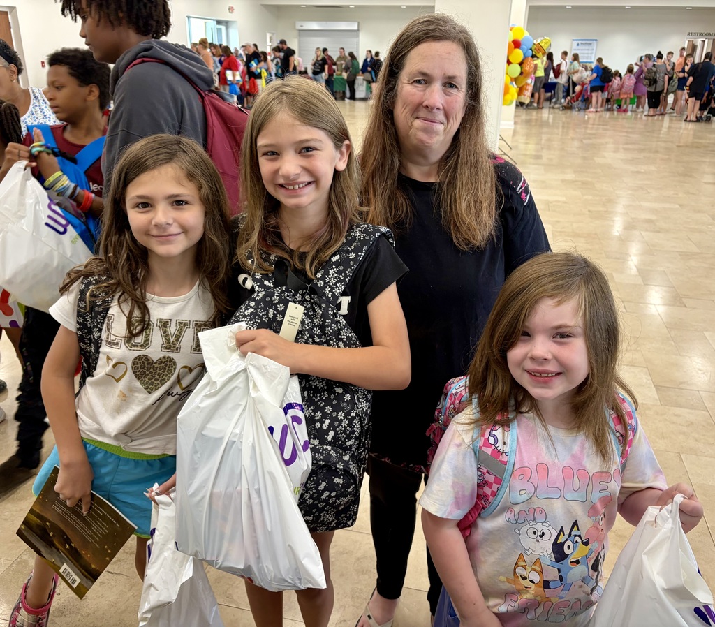 A parent standing with her smiling children