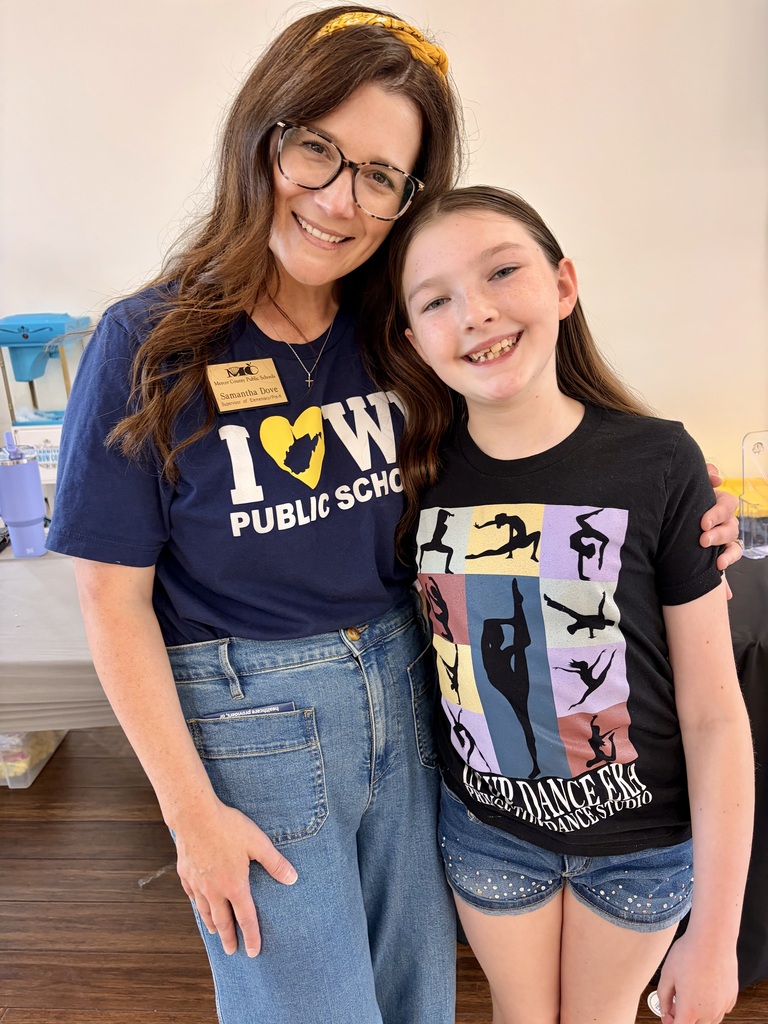 A smiling woman with her arm around a student