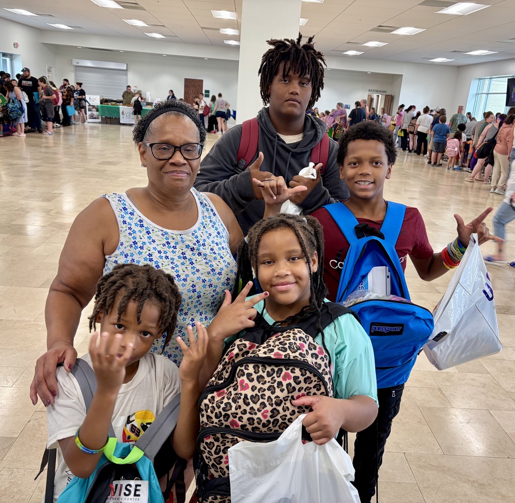 A family posing and showing peace signs