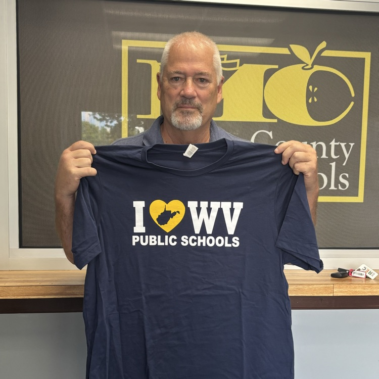 delegate Gearheart holding up an I love WV Public Schools t shirt