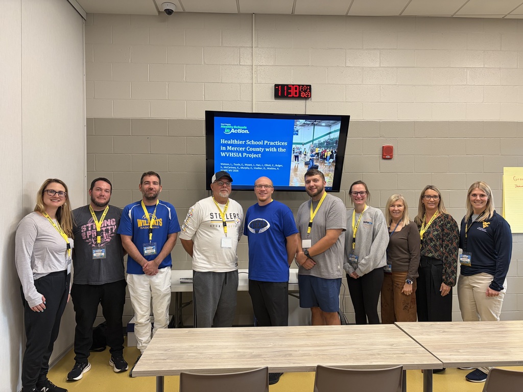 A group of teachers standing in front of a backdrop. They are attending a training for health and PE teachers