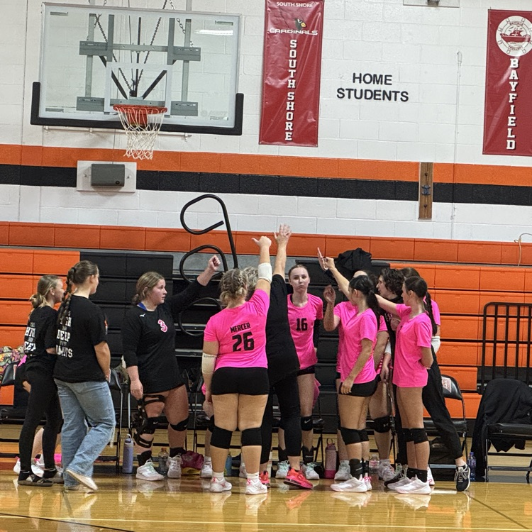 volleyball team hands raised in center of huddle