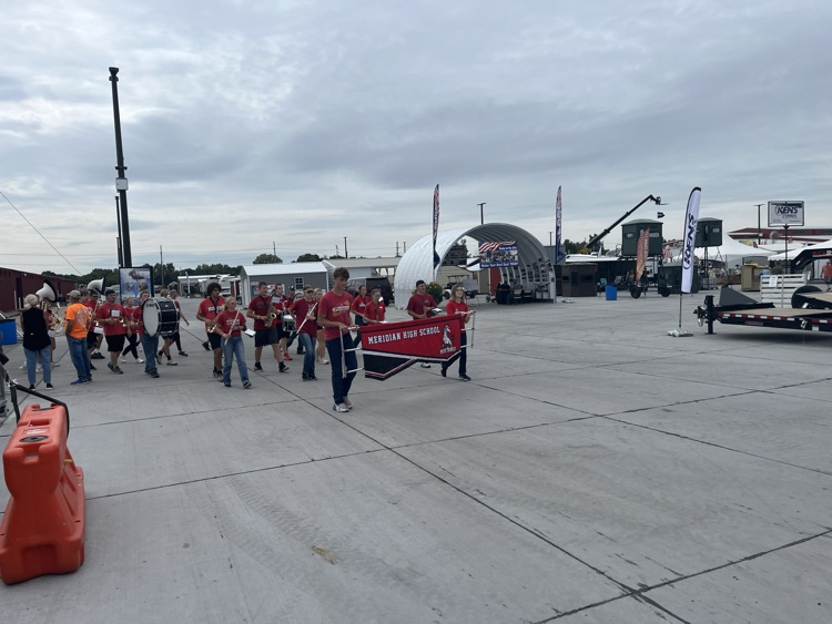 Band members marching and playing at the state fair.