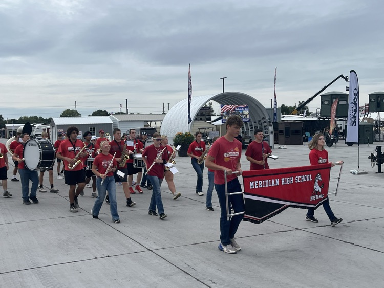 Band members marching and playing at the stat