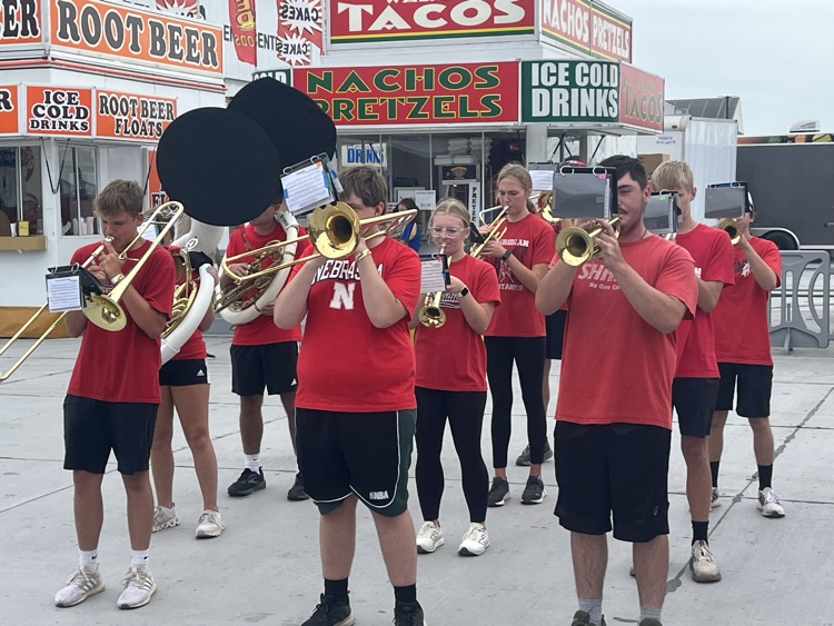 Band members marching and playing at the stat