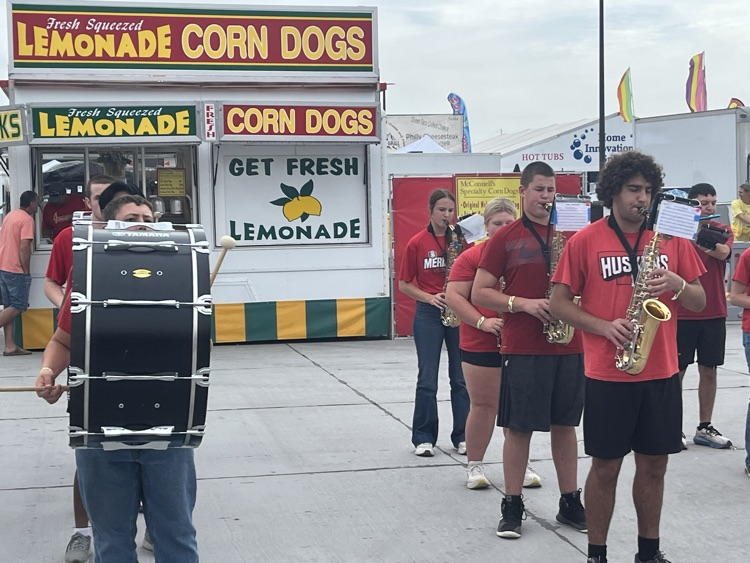 Band members marching and playing at the stat