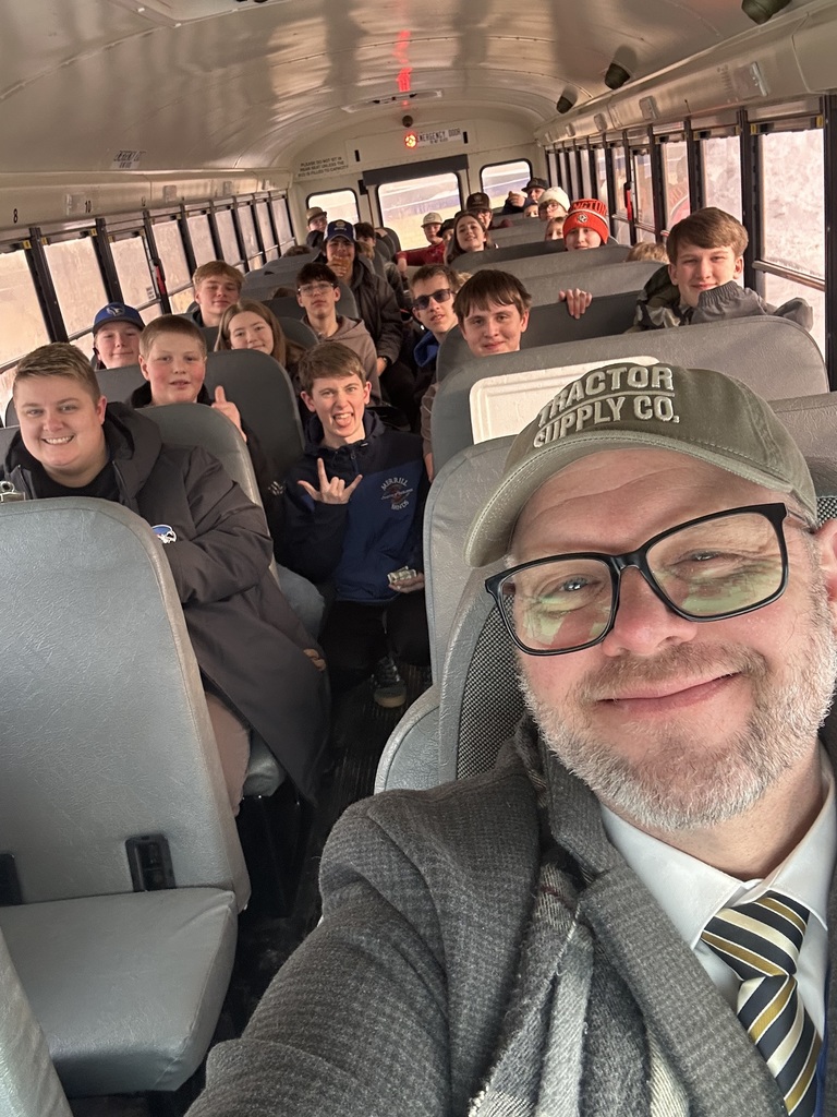 Mr. Murray in the drivers seat of a bus full of students and staff