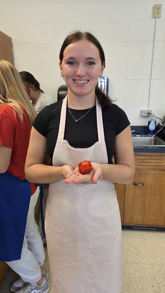 Student holding a flower made out of food