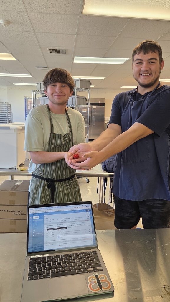 Two students holding a strawberry